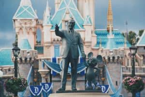 Walt Disney in front of castle with Mickey